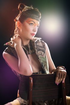 Portrait of fashion woman on a dark background illuminated by colored lights.