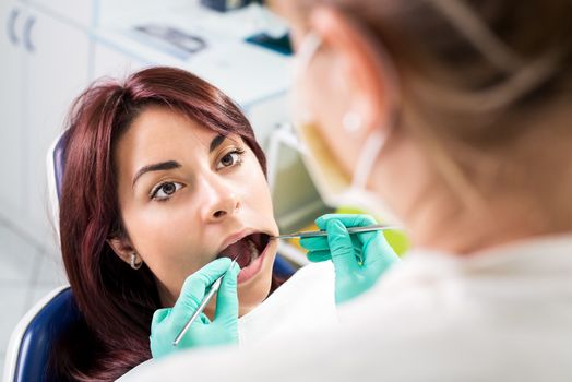 Dentist checking dental hygiene on patient in the office.