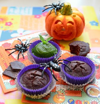 Halloween cupcakes with a orange pumpkinhead, spiders and green frosting