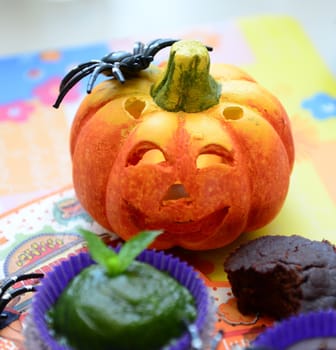 Orange smiling pumpkin head with a spider on top for Halloween