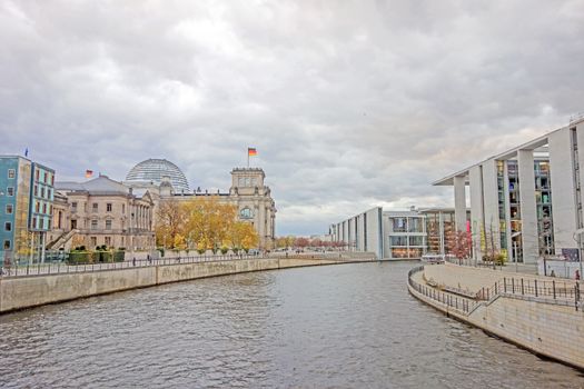 Berlin, Germany - October 28, 2013: Spree river and Reichstag building in the background. Government district in Berlin-Mitte, where politic is made in Germany.