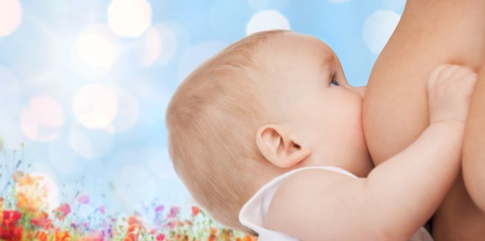 motherhood, children, people and care concept - close up of mother breast feeding adorable baby over blue sky with lights and poppy field background