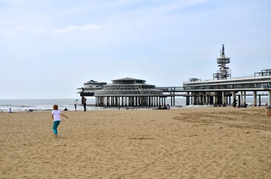 The Hague, Netherlands - May 8, 2015: Children playing at the beach, Scheveningen district in The Hague, Netherlands. Scheveningen is a modern seaside resort with a long sandy beach, an esplanade, a pier, and a lighthouse.