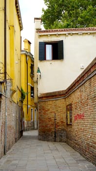 Alley with ancient brick fence building in Venice, Italy