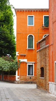 Alley with orange ancient building in Venice, Italy