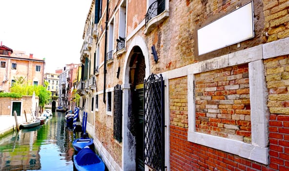 canal and boats with ancient buildings horizontal in Venice, Italy