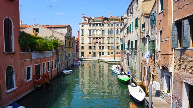 canal and boats with ancient buildings in Venice, Italy