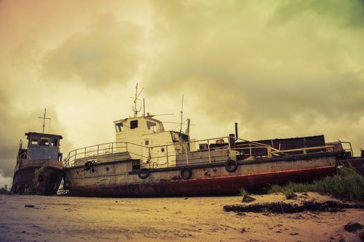 Old wrecked boat on the coast. Autumn sky background.