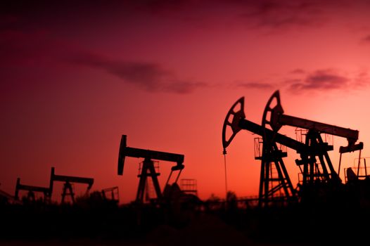 Oil pumps at sunset sky background. Selective focus, shallow depth of field.