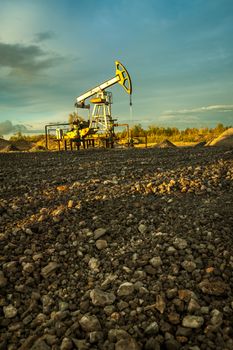 Oil pump jacks at sunset sky background.