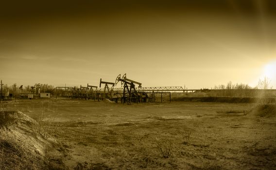 Pump jack group and wellheads. Extraction of oil. Toned.