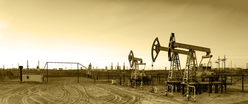 Oil and gas industry. Panoramic of a pumpjack and oil refinery. 