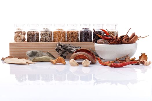 Assorted of spice bottles condiment black pepper ,white pepper, black mustard,white mustard,fenugreek,cumin ,bay leaf ,cinnamon and fennel seeds with mortar isolated on white background.