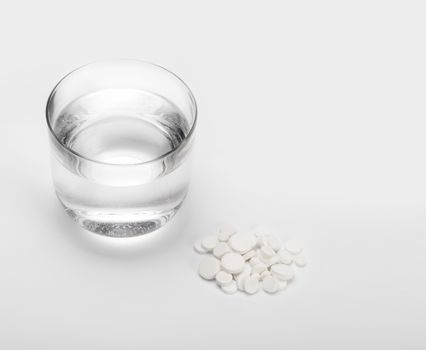 tablets and pills and glass of water