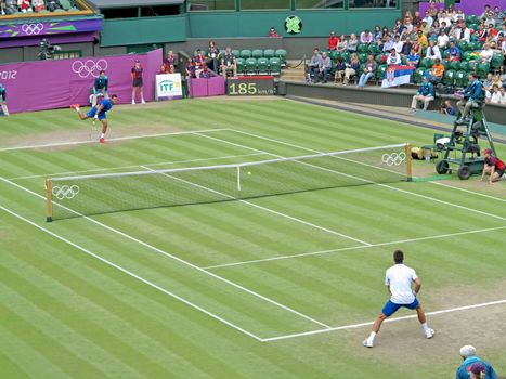 WIMBLEDON, ENGLAND - August 2nd, 2012 - Novak Djokovic and Jo-Wilfried Tsonga during their singles match at the summer Olympics in London in 2012. Novak Djokovic took 4th place and Jo-Wilfried Tsonga made it to the quarterfinals in the tournament.