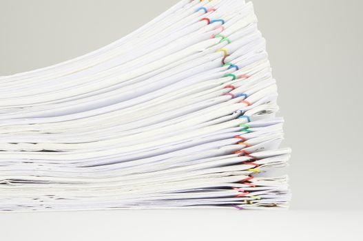 Pile of paper of report and paperwork on table near wall.