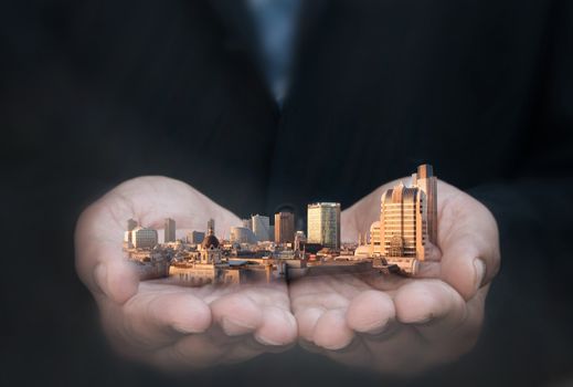 Business man holding city skyline skyscrapers and buildings 