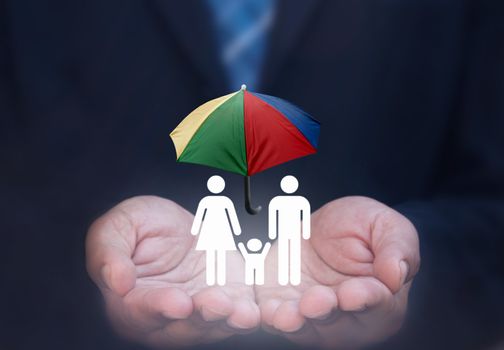 Business man holding lit up house symbol with umbrella protection