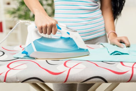Close-up of a woman hands is ironing clothes.