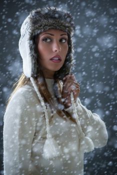 Portrait of a beautiful young woman in winter clothes at snow.