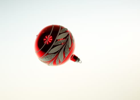 Red Christmas bauble with light reflections ona white isolated background.Horizontal view.