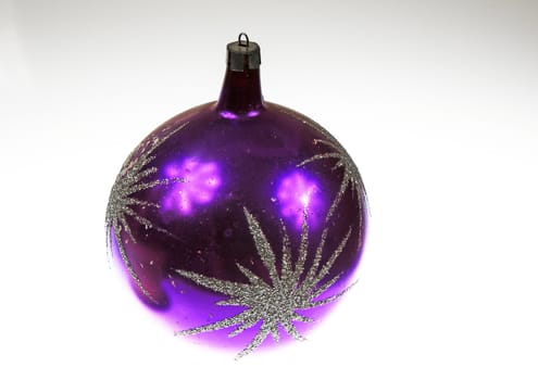 A large purple Christmas bauble decorated with brocade stars, with light reflections on an isolated white background.Horizontal view.