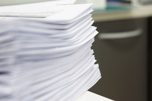 Pile of copy document placed on white desk at office.                               