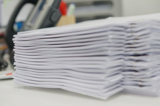 Pile of copy document placed on white desk at office.                               