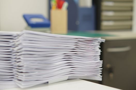Stack of copy document placed on white desk at office.                               