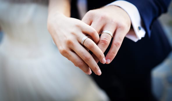 Hands and rings on wedding bouquet