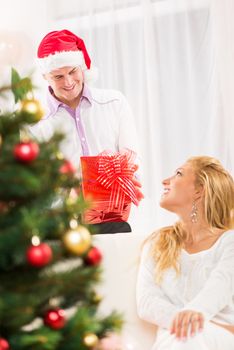 Young man gives his girlfriend a Christmas gift.