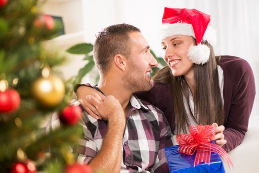 Young beautiful couple exchanging a Christmas gifts.
