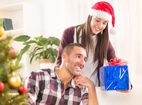 Young beautiful couple exchanging a Christmas gifts.