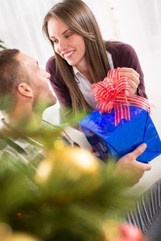 Young man gives his girlfriend a Christmas gift.