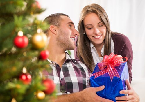 Young man gives his girlfriend a Christmas gift.