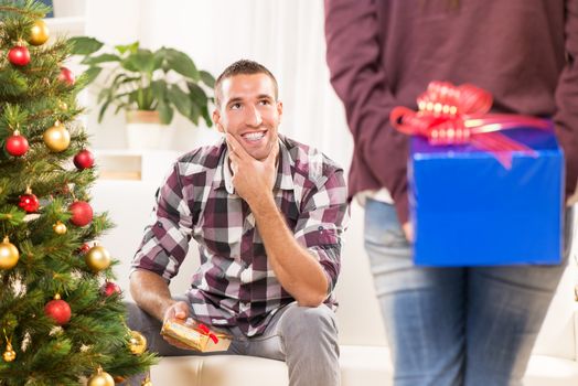 Young beautiful girl has a Christmas present for her boyfriend and she wants to surprise him.