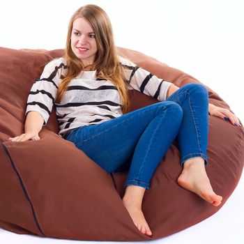 cute girl sitting on a braun beanbag chair.