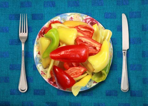 bell peppers on plate, knife and fork on table