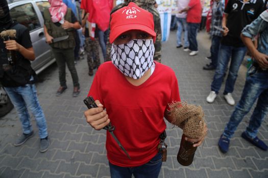 GAZA, Gaza City: A masked member of the Popular Front for the Liberation of Palestine holds a knife while participating in a protest in Gaza on October 20, 2015. The group is rallying against what it perceives to be Israeli aggression in Jerusalem, the occupied West Bank and Gaza region over the past month, during which an upsurge of violence, including stabbing and gun attacks, has led to the deaths of at least 37 Palestinians and seven Israelis.    