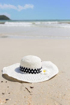 Straw hat and plumeria on the beach