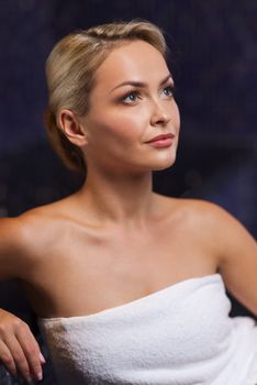 people, beauty, spa, healthy lifestyle and relaxation concept - beautiful young woman sitting in bath towel