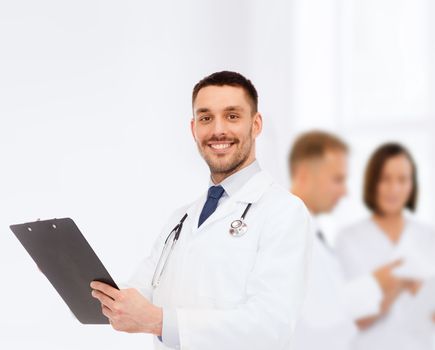 medicine, profession, and healthcare concept - smiling male doctor with clipboard and stethoscope writing prescription over white background