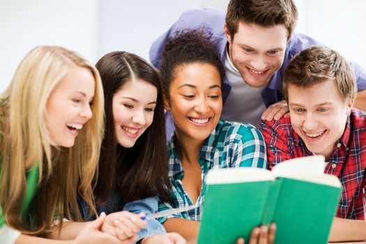 education concept - group of students reading book at school