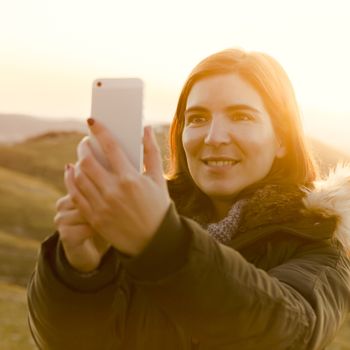 Beautiful woman in outdoor making a selfie