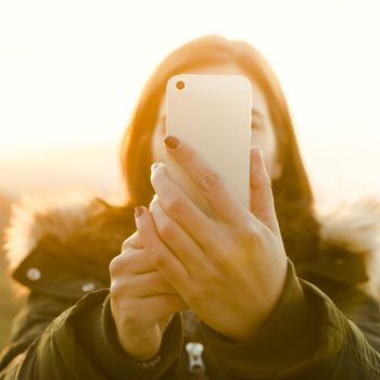 Beautiful woman in outdoor making a selfie