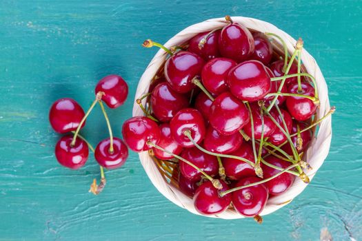 fresh cherries on green wooden table