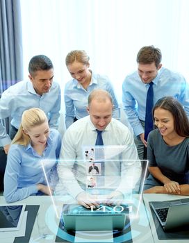 business, people, technology and teamwork concept - smiling business team with laptop computer and virtual projection working in office