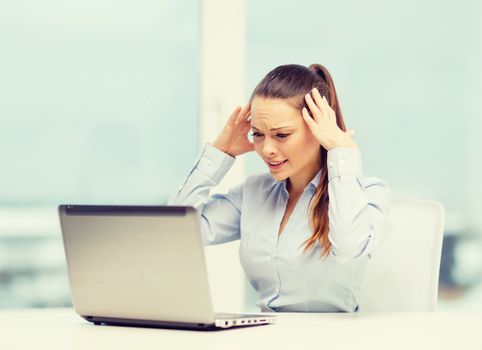 business, office and technology concept - stressed businesswoman with laptop at work