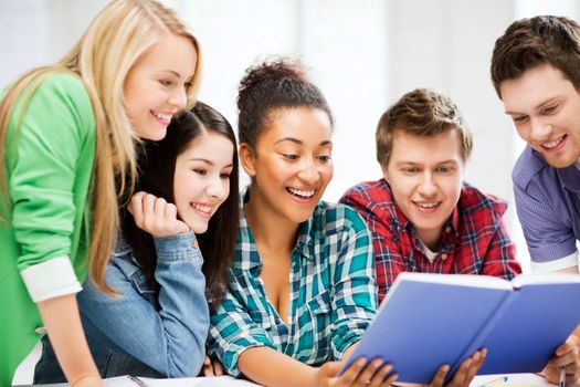 education concept - group of students reading book at school