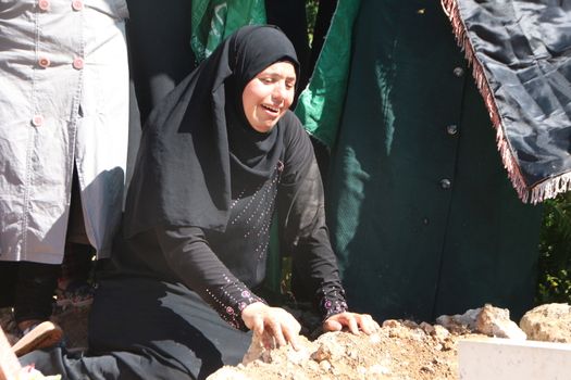 PALESTINE, Hebron: Violence continued in Hebron, Palestine on October 21, 2015 as Palestinians' held a funeral service for a fallen man. Women mourn over the grave of the man who was killed.Hebron was the latest scene of violence as an IDF soldier was stabbed by an attacker on Tuesday. The attacker was shot and killed after the stabbing. 